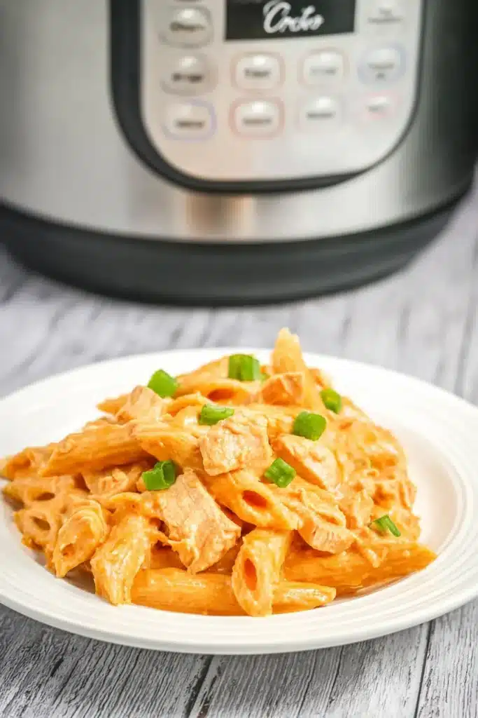 Creamy Buffalo Chicken Pasta plated in front of a slow cooker