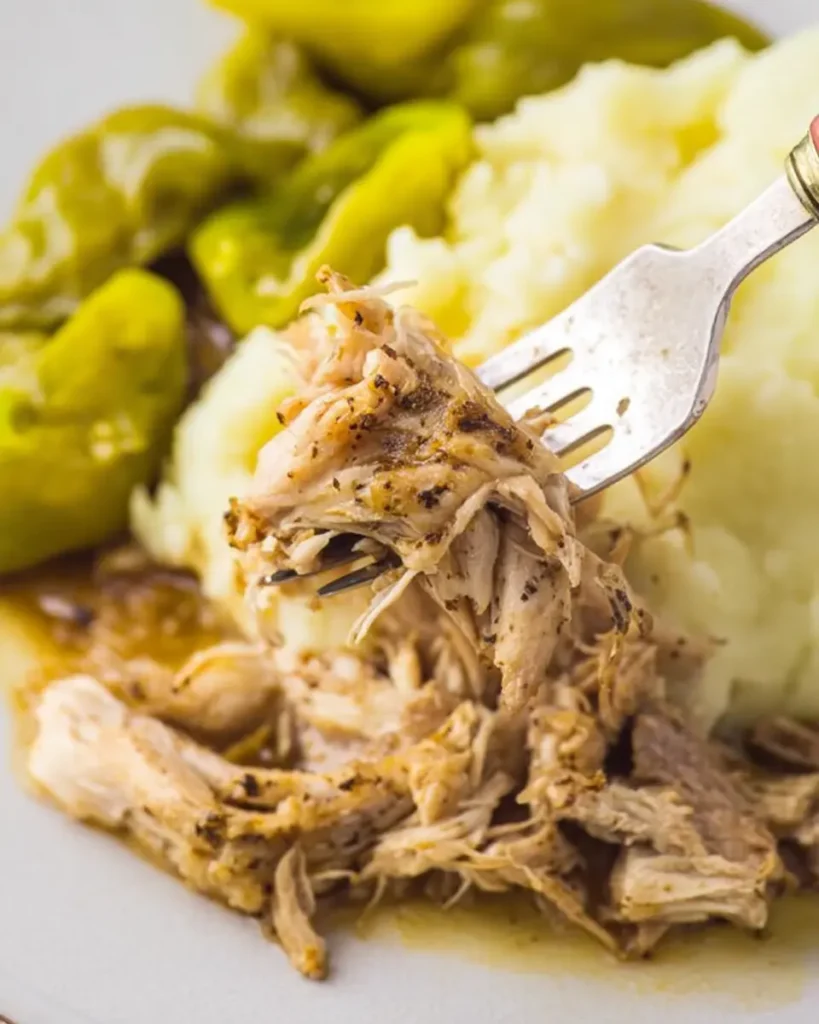 Close-up of forkful of tender shredded Mississippi Chicken with mashed potatoes.