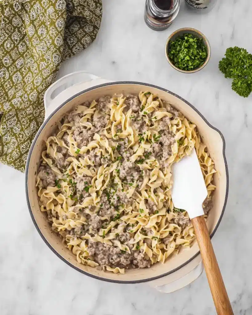 Comforting ground beef stroganoff fully cooked in skillet with creamy noodles and parsley