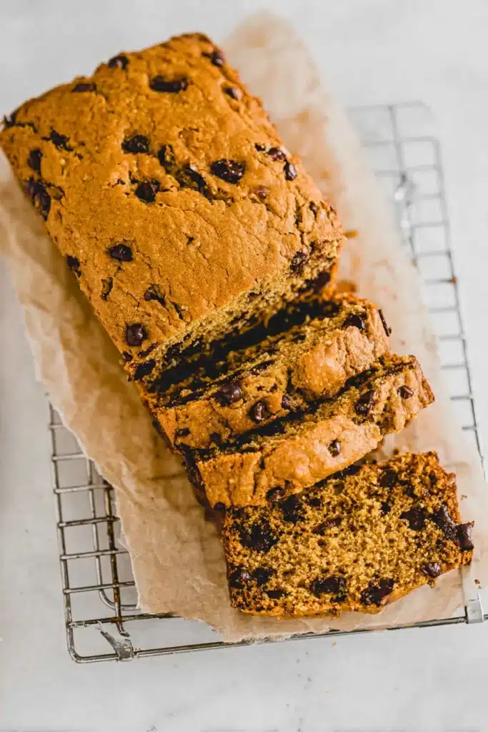 Top-down view of sliced vegan pumpkin chocolate chip bread on parchment paper