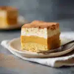 "Single slice of pumpkin magic custard cake showing three layers on a ceramic plate with fork"