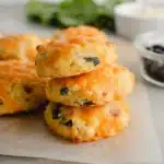 Golden breakfast protein biscuits with melted cheddar on parchment