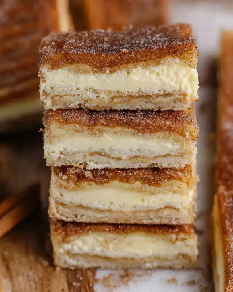 Churro cheesecake bars with cinnamon sugar crust and creamy cheesecake filling