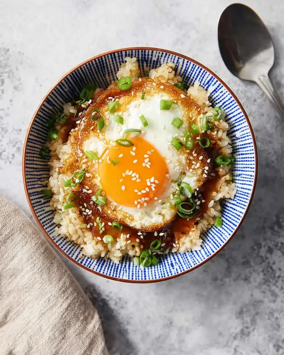 Bowl of easy Korean egg rice topped with a crispy fried egg, green onions, and sesame seeds.