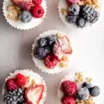Top view of frozen yogurt granola cups topped with frozen berries and crunchy granola.