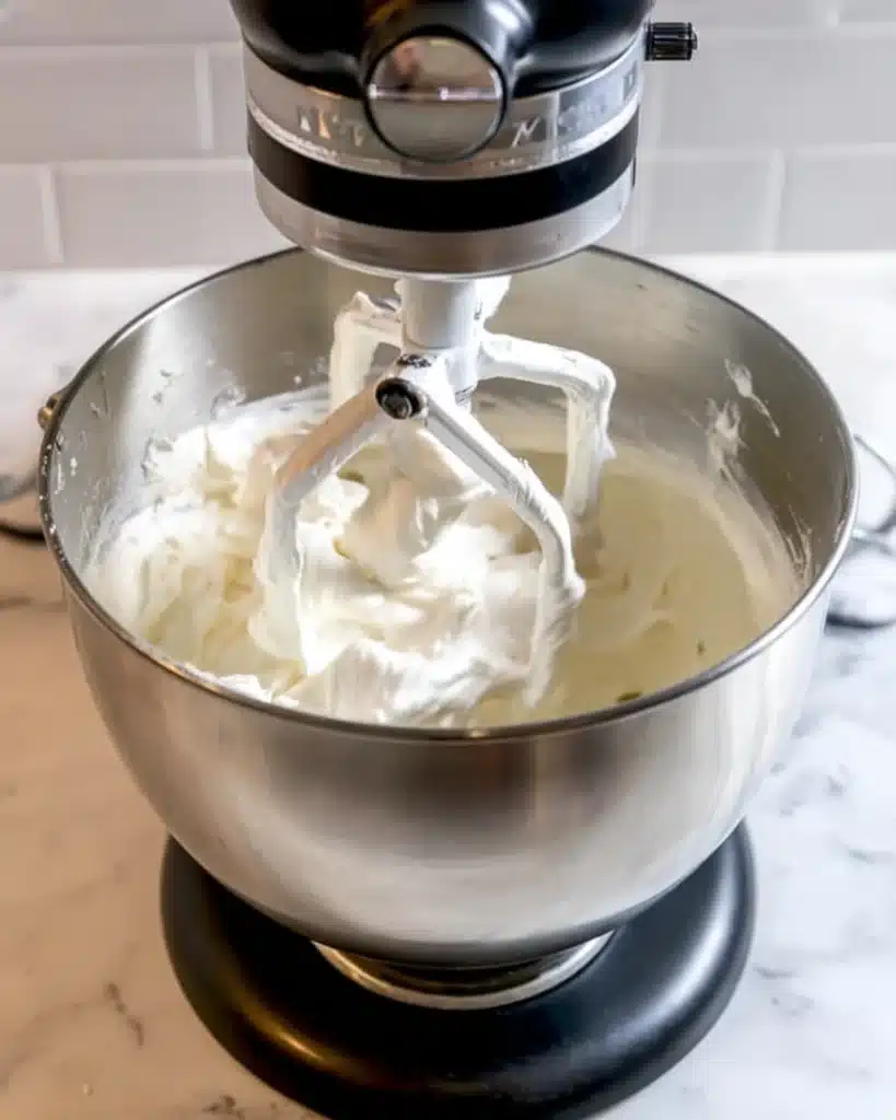 Whipping vanilla buttercream frosting for Halloween Vampire Bite Cupcakes in a stand mixer