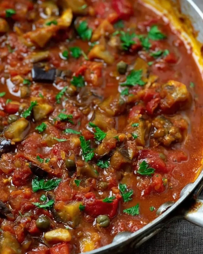 Mediterranean eggplant pasta sauce simmering in a pan with tomatoes and vegetables