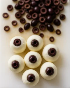 Mozzarella balls with kalamata olive pupils for Halloween salami eyeball skewers