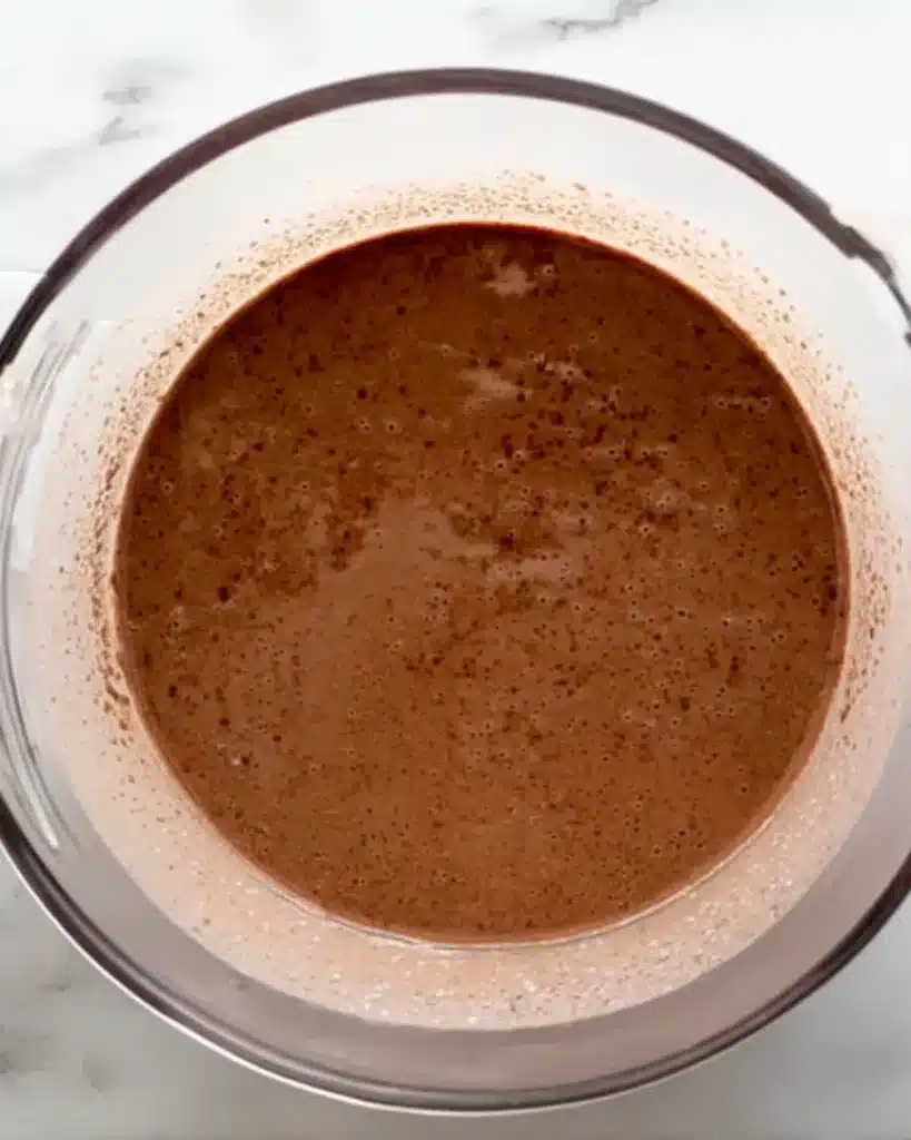 Chocolate cupcake batter in a clear bowl for Halloween Vampire Bite Cupcakes