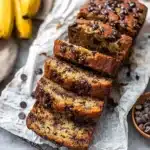 Sliced chocolate chip banana bread with melted chocolate on parchment