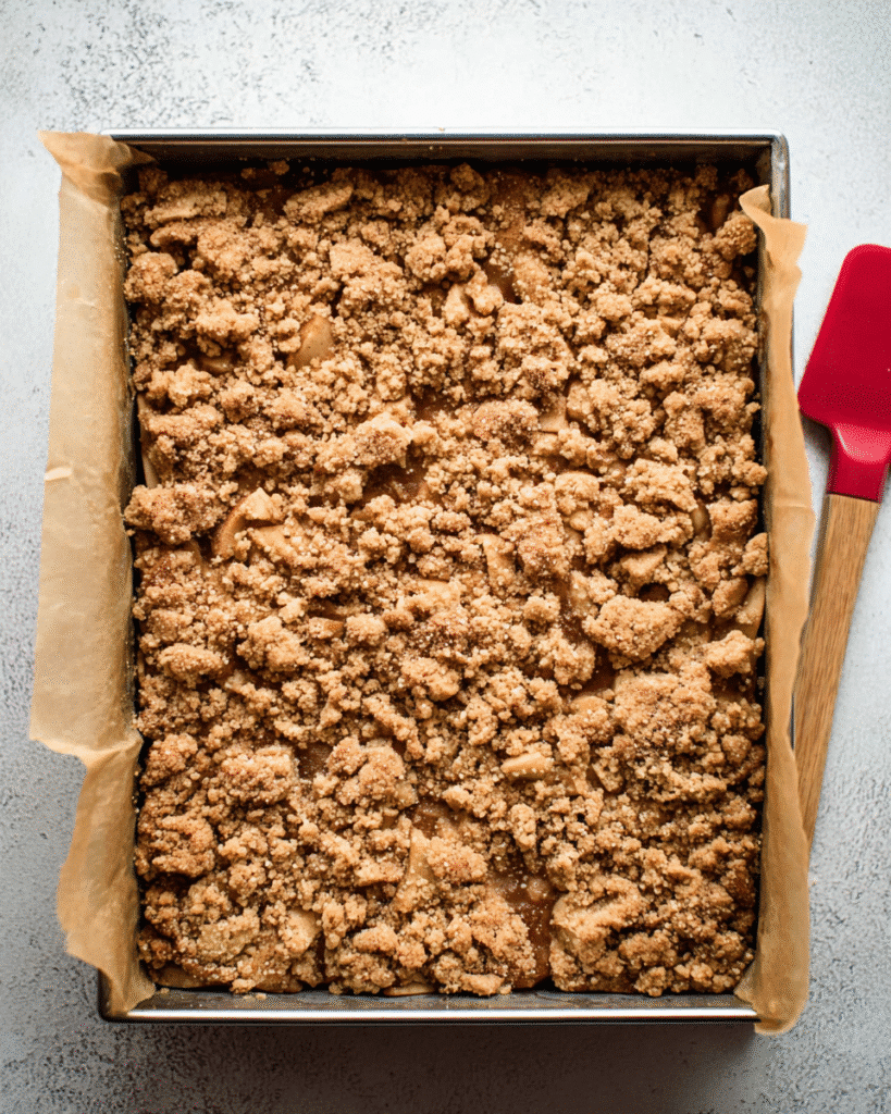 Baked apple crumb cake in a pan with golden crumb topping