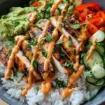 Bang Bang chicken bowl with rice, vegetables, and spicy sauce