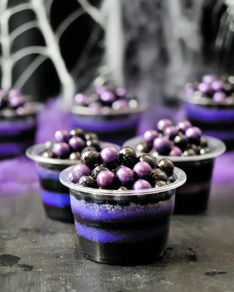 Black Magic Jello Shots with purple layers and boba pearls for Halloween