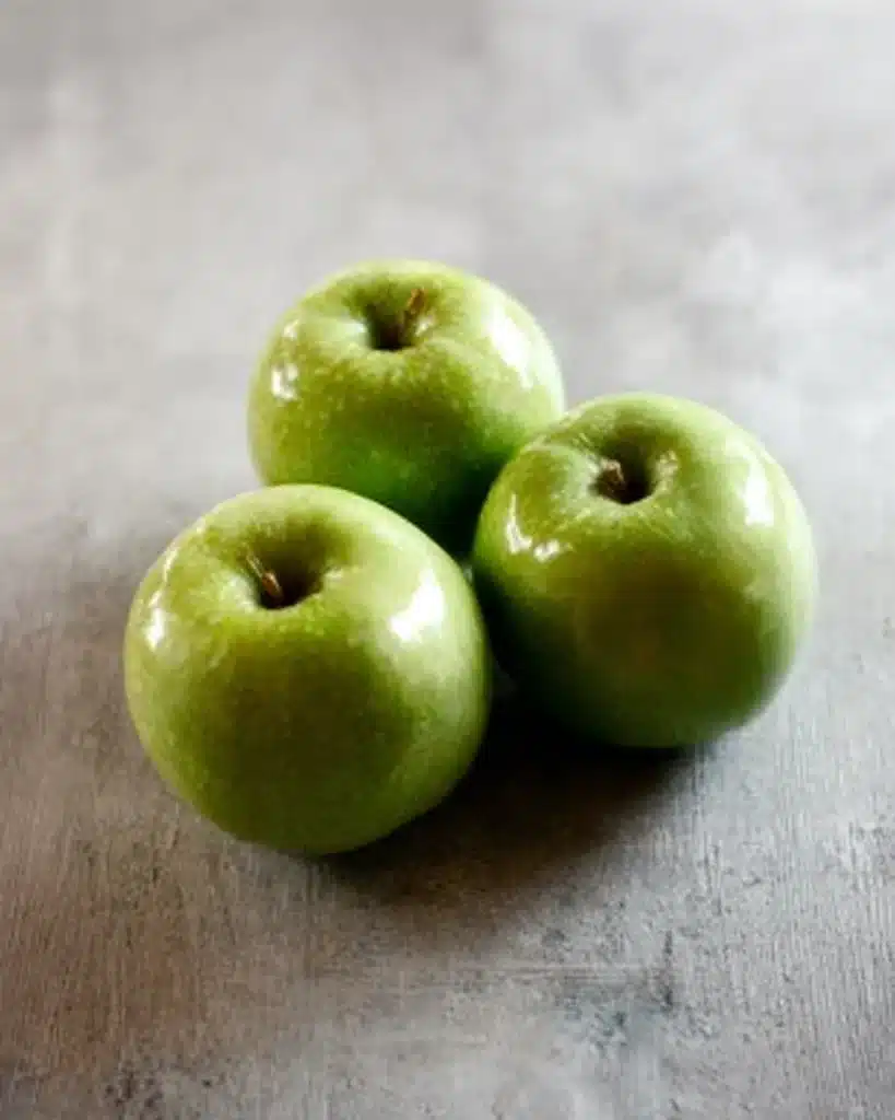 Fresh green Granny Smith apples on a rustic surface