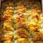 Golden baked cheesy scalloped potatoes with crispy edges in a ceramic dish