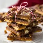 Stacked Christmas Crack Toffee with chocolate and pecans tied with festive string