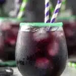 Halloween Drunk Witch cocktail with green sugar rim and striped straws