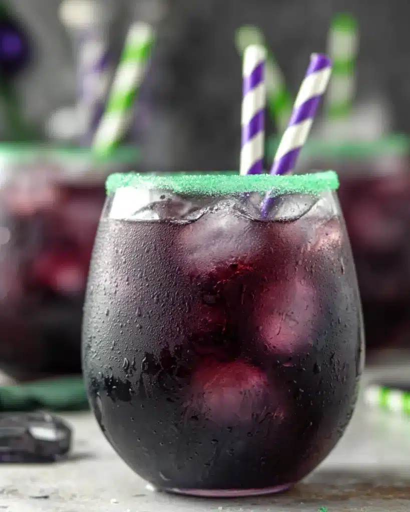 Halloween Drunk Witch cocktail with green sugar rim and striped straws