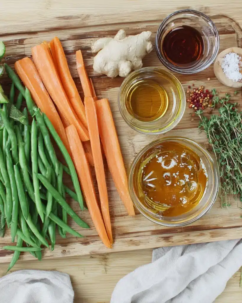 Fresh ingredients for flavorful roasted carrots and green beans on cutting board