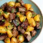 Garlic Butter Steak and Potatoes served in a bowl with herbs