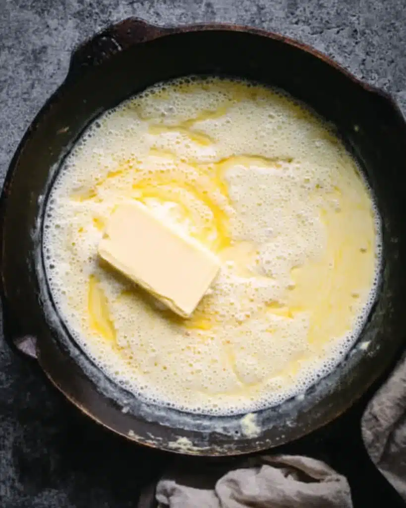 Milk and butter melting together in a cast iron skillet