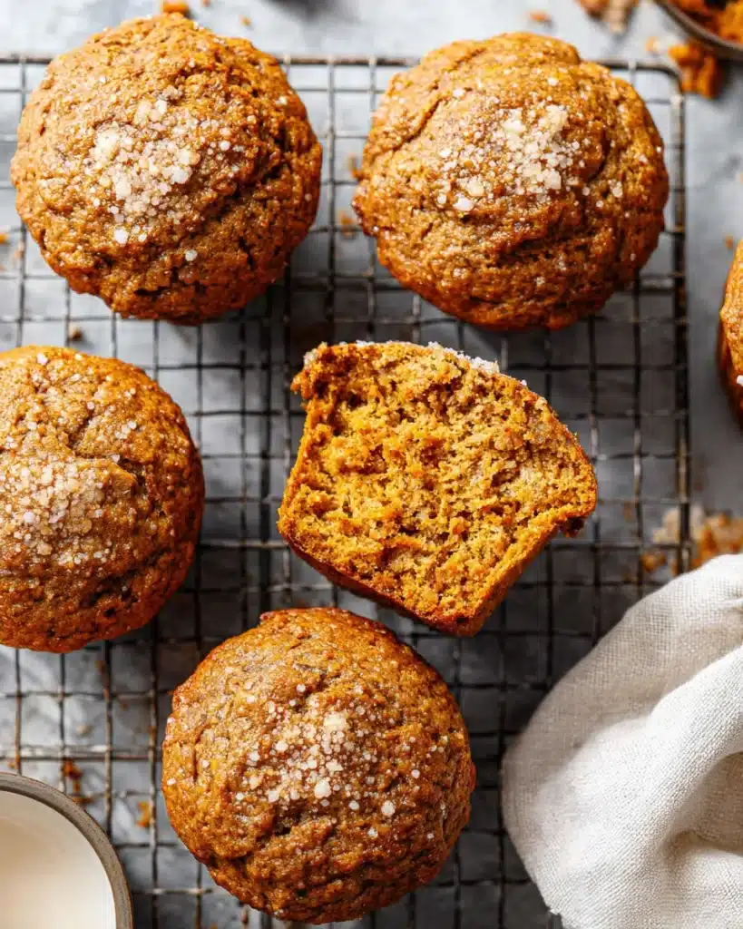 Freshly baked healthy pumpkin muffins on cooling rack with one cut open