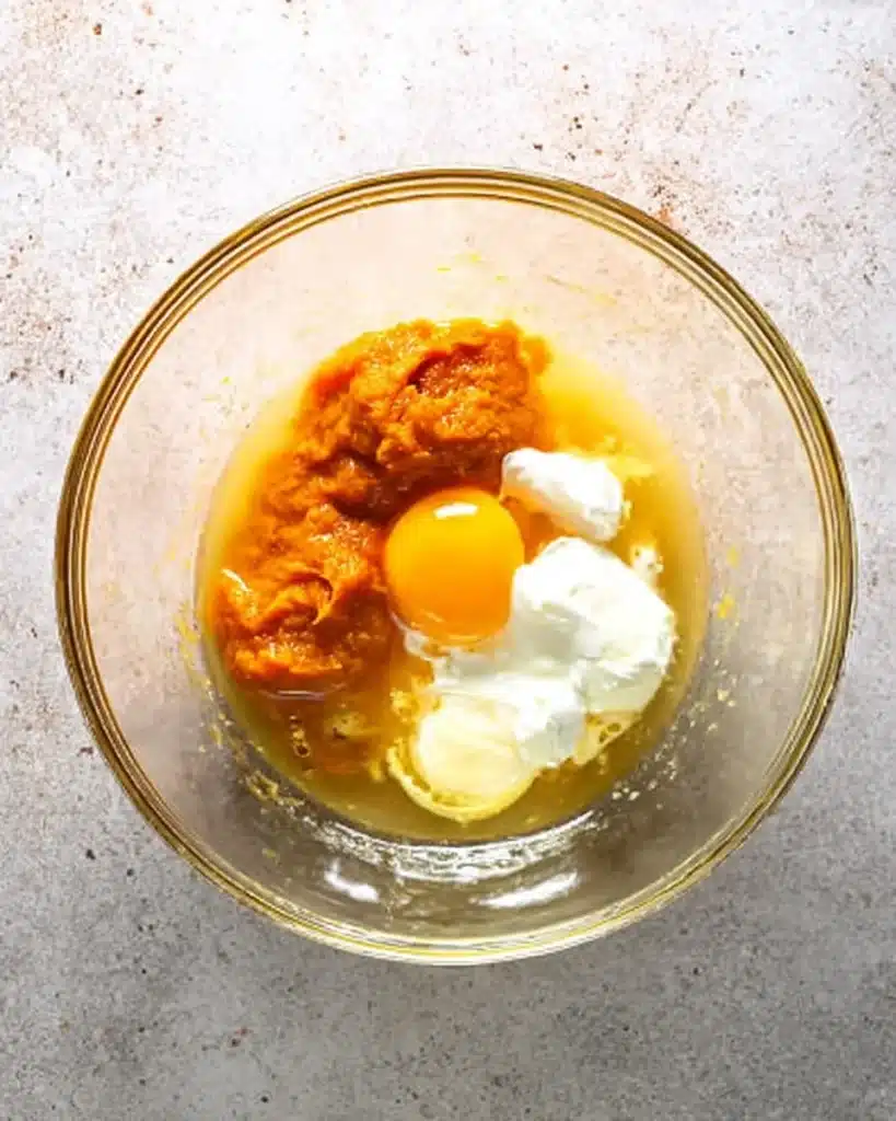 Wet ingredients for healthy pumpkin muffins in glass bowl before mixing