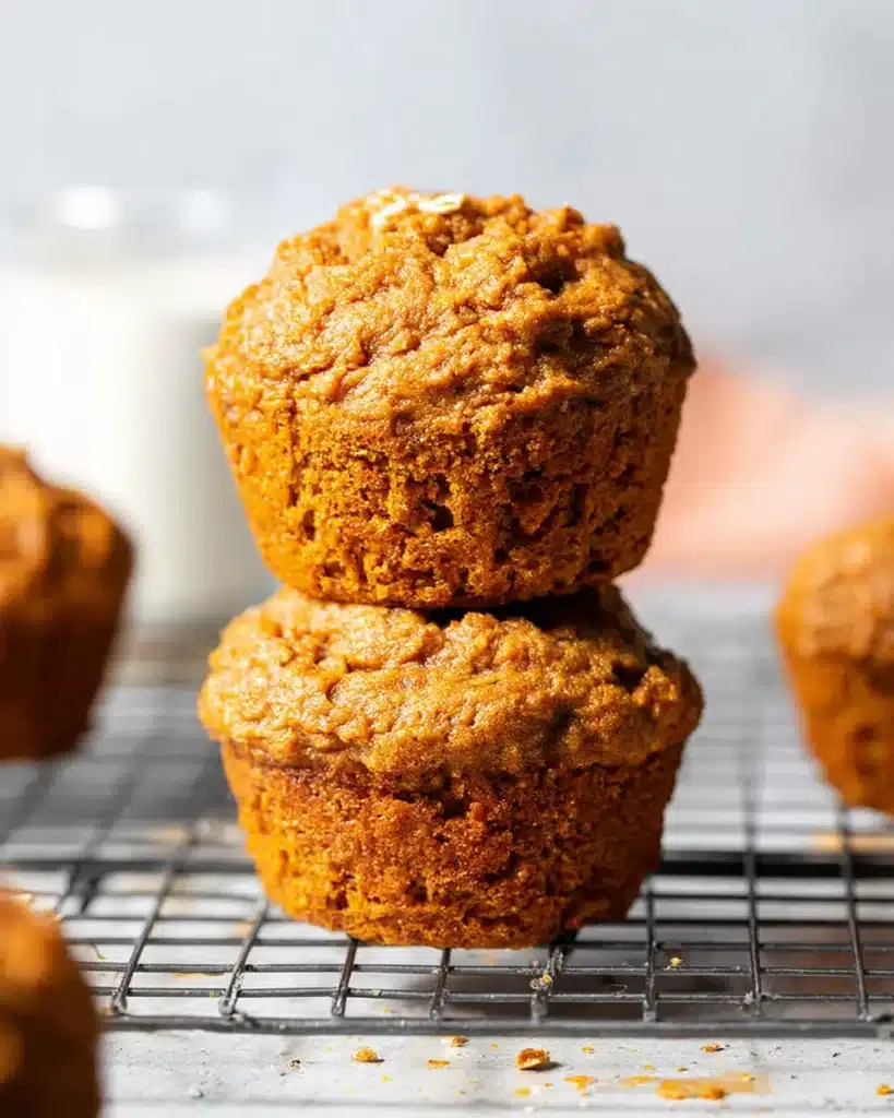 Freshly baked healthy pumpkin muffins stacked on cooling rack