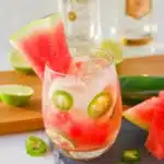 Finished La Bruja Cocktail with watermelon wedge and jalapeño garnish