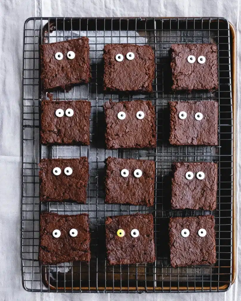 Brownie squares cooling on rack with candy eyes for Mummy Brownies