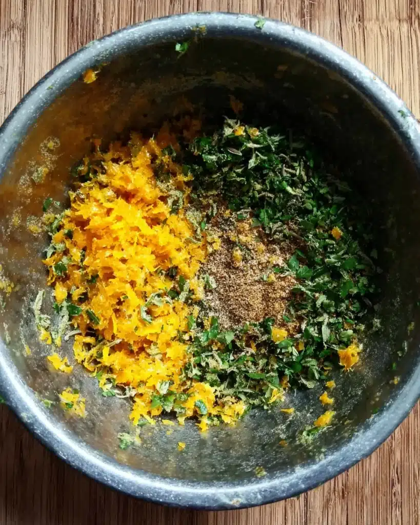 Orange zest, herbs, and spices in a bowl for Orange Chicken Roast with Fennel and Shallots marinade