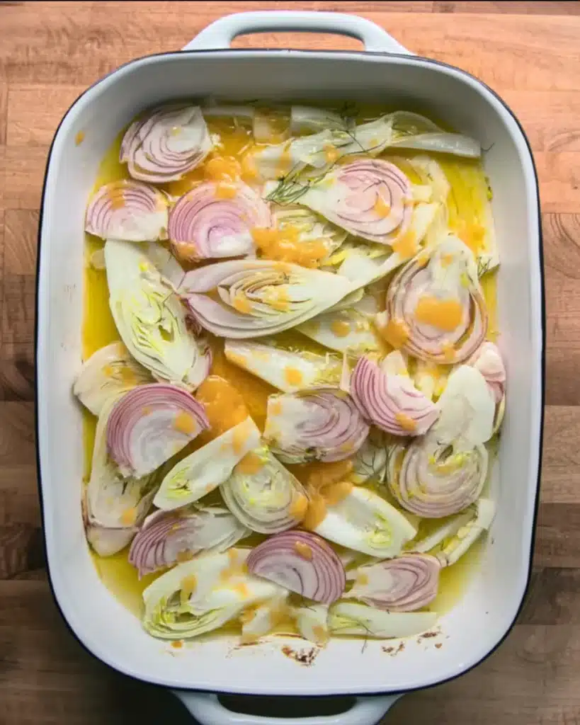 Fennel and shallots layered in orange juice for Orange Chicken Roast with Fennel and Shallots