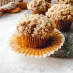 Pumpkin cinnamon streusel muffins with crumbly topping on rustic stone