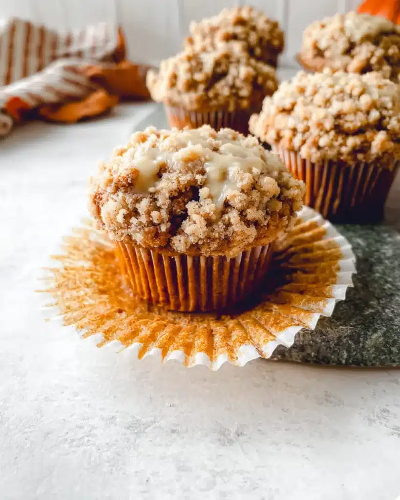 Pumpkin cinnamon streusel muffins with crumbly topping on rustic stone