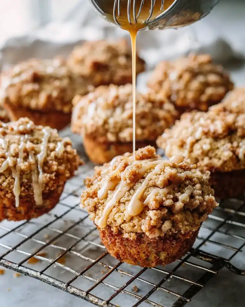 Pumpkin cinnamon streusel muffins on cooling rack with glaze drizzle