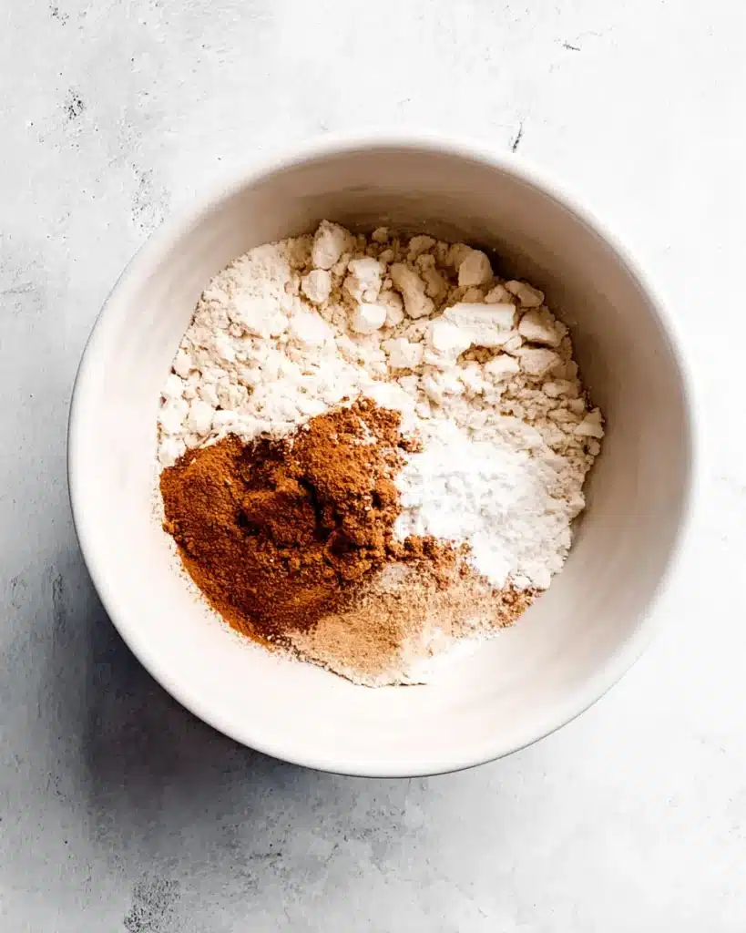 Mixing flour and cinnamon for pumpkin chocolate chip muffins