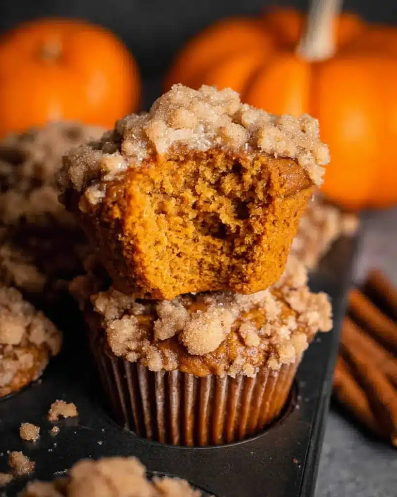Pumpkin streusel muffin with bite showing moist spiced center