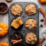 Pumpkin streusel muffins in a tin with spices and crumb topping