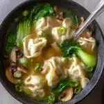 Bowl of quick and easy wonton soup with dumplings, bok choy, and shiitake mushrooms