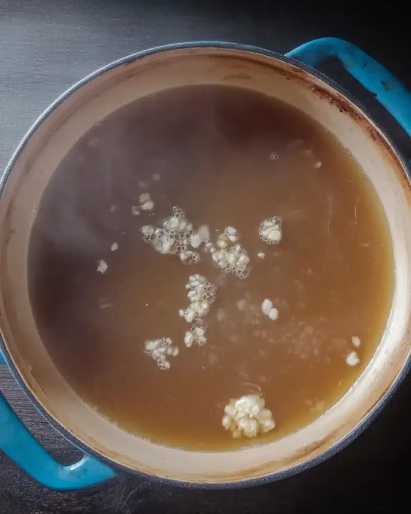 Simmering broth with garlic in pot for quick and easy wonton soup