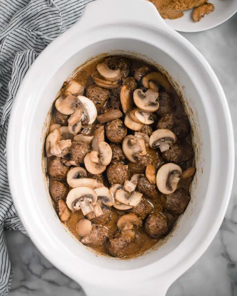 Frozen Salisbury steak meatballs with sliced mushrooms in slow cooker