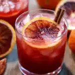 Glass of Witches Brew punch with cloves, cinnamon stick, and blood orange slice