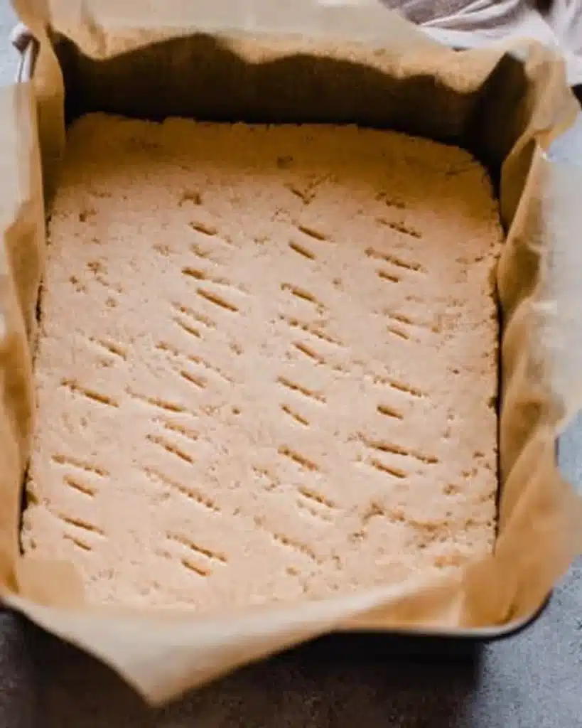Unbaked shortbread crust pressed in pan for salted maple pecan pie bars