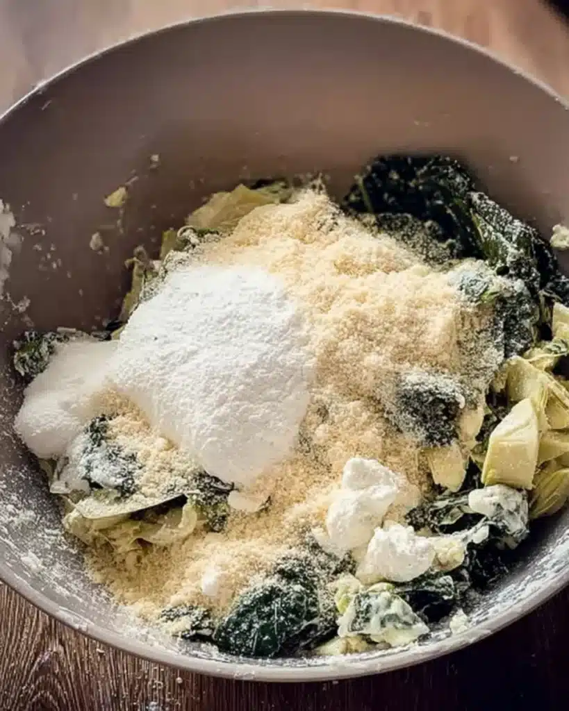 Spinach, artichokes, cream cheese, and parmesan in mixing bowl for filling