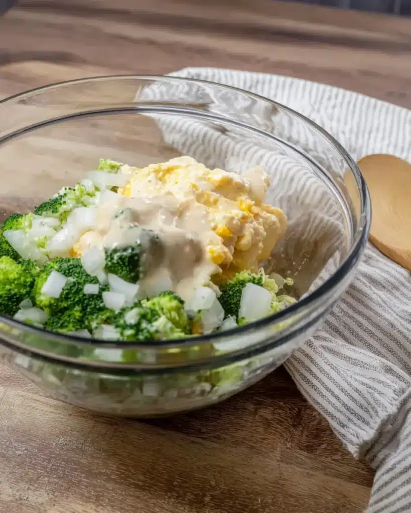 Broccoli cheese casserole ingredients in a glass mixing bowl