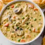 Chicken pot pie soup with biscuits on marble table