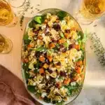 Fall harvest pasta salad with roasted sweet potatoes, spinach, and feta under warm sunlight