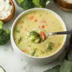 Close-up of high protein broccoli cheddar soup in bowl with spoon