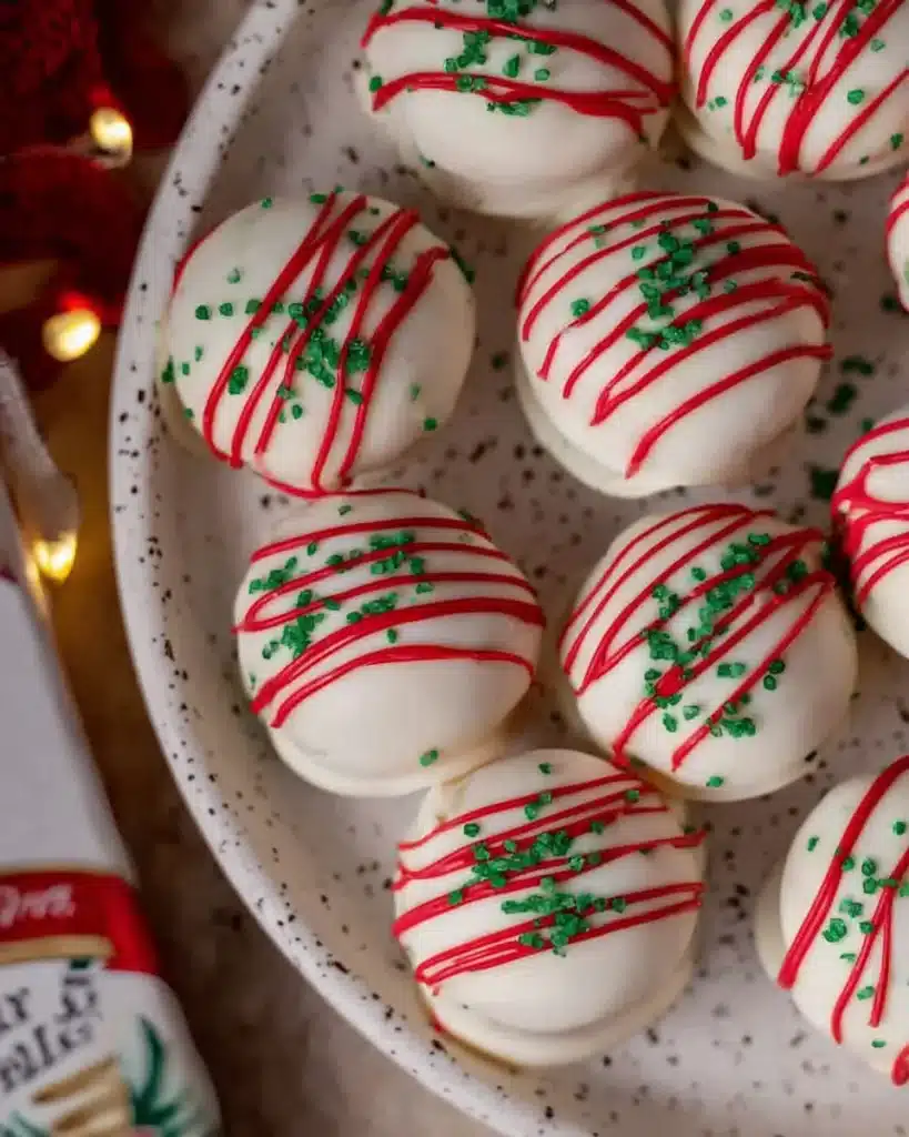 Little Debbie Christmas Tree Cake Truffles with red stripes and green sprinkles on a speckled white plate.