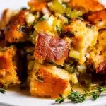 Golden brown Thanksgiving stuffing with crispy bread cubes, herbs, and celery on a plate